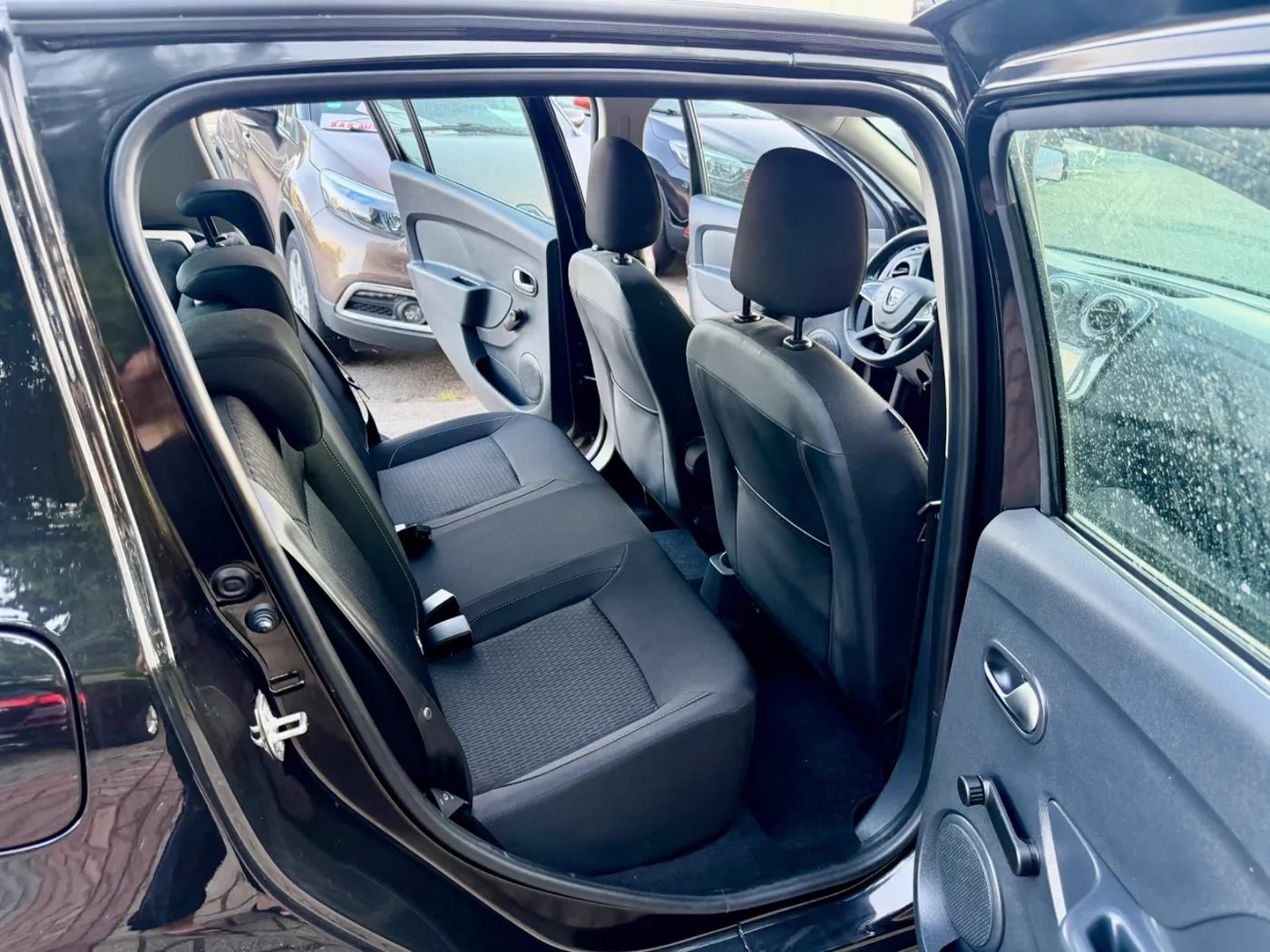 Saubere Rücksitzbank eines Dacia Sandero, Blick durch die offene hintere Tür