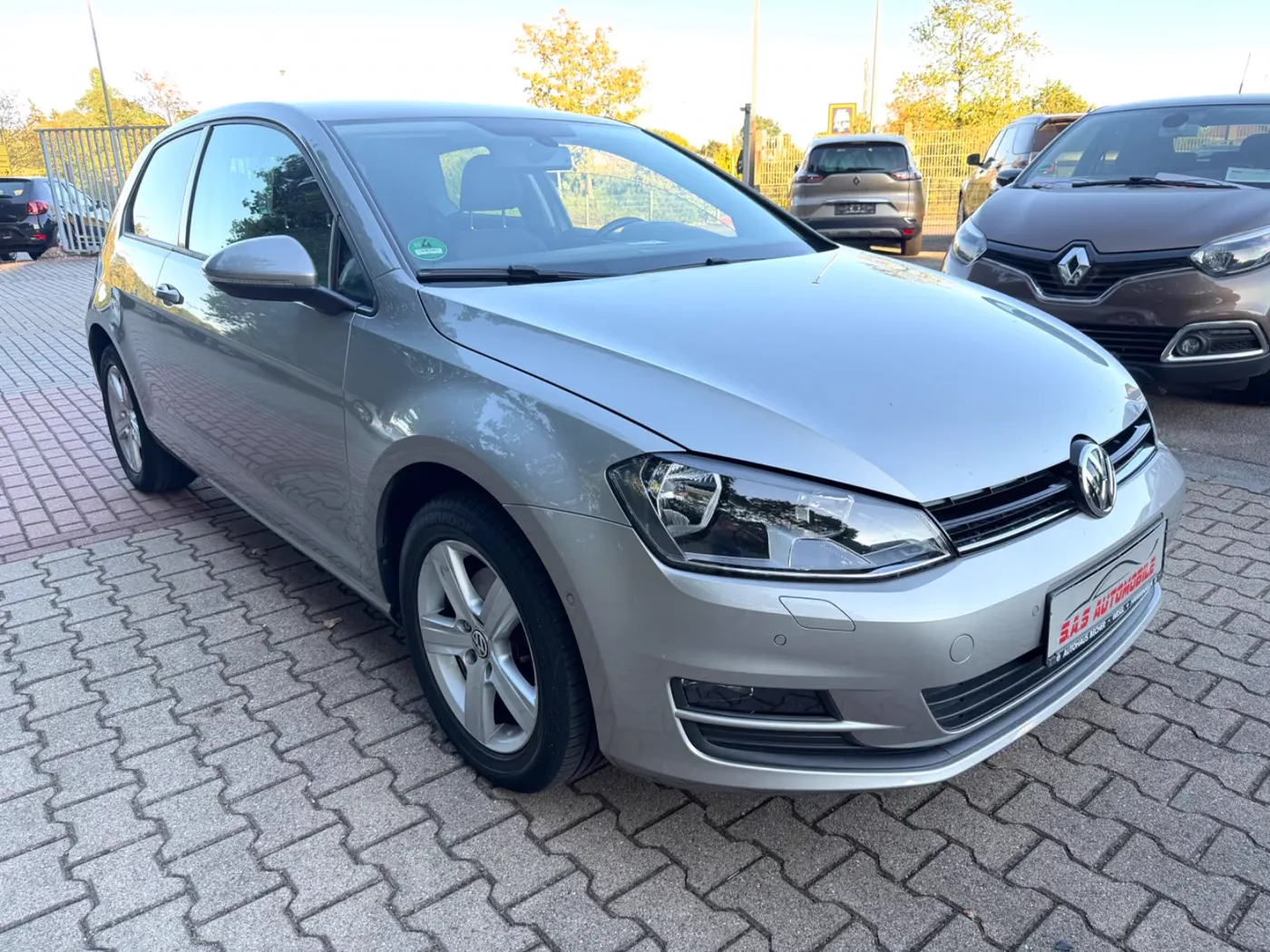 Silberner Volkswagen Golf VII Comfortline auf dem gepflasterten Hof von S.A.S Automobile